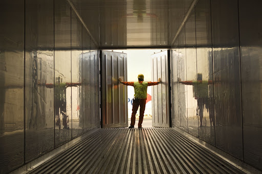 A man with a hard hat standing in a shipping container.